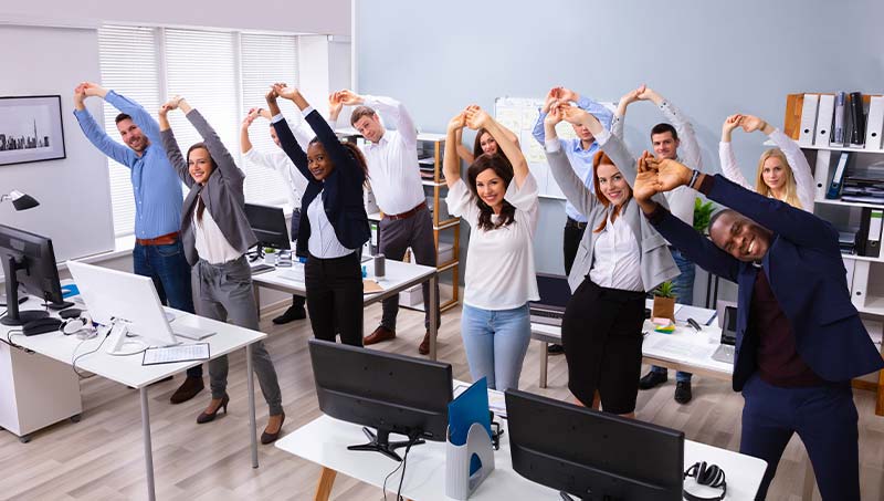 office staff stretching together following the advice of a Wilmington Chiropractor at Cowan Chiropractic & Rehabilitation
