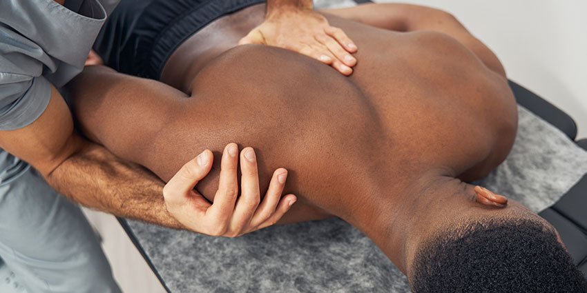 Wilmington chiropractor at Cowan Chiropractic & Rehabilitation adjusting patient's shoulder to relieve pain